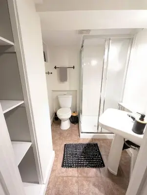 a bathroom with a shower and a toilet and a sink at Charming Basement Studio Bathroom Full Kitchen in Toronto