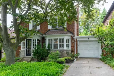 a brick house with a white garage at Charming Basement Studio Bathroom Full Kitchen in Toronto