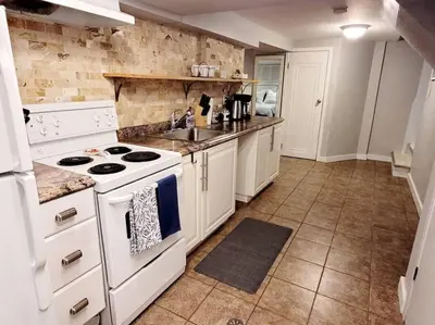 a kitchen with a white stove and a sink at Charming Basement Studio Bathroom Full Kitchen in Toronto