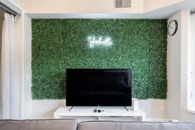 a living room with a tv and a green wall at Discounted Elegant Yorkville Suite in Toronto
