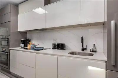 a kitchen with white cabinets and a sink at Casa Hotel Elegant Suite w Patio BBQ Grill in Toronto