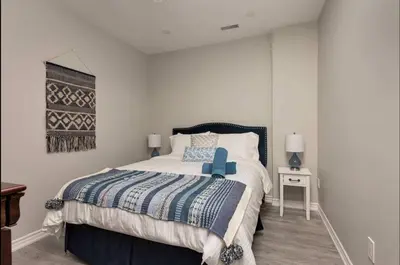 a bedroom with a large bed with a blue foot board at Casa Hotel Elegant Suite w Patio BBQ Grill in Toronto