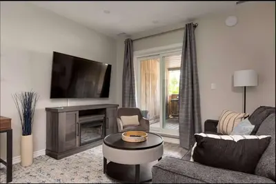 a living room with a fireplace and a tv at Casa Hotel Elegant Suite w Patio BBQ Grill in Toronto