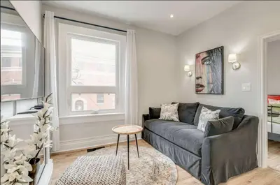 a living room with a couch and a table at Casa Leslieville - 2BR Suite with LRG Patio in Toronto