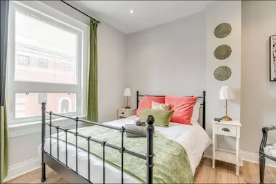 a bedroom with a bed with red pillows and a window at Casa Leslieville - 2BR Suite with LRG Patio in Toronto