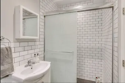 a white bathroom with a sink and a shower at Casa Leslieville - 2BR Suite with LRG Patio in Toronto