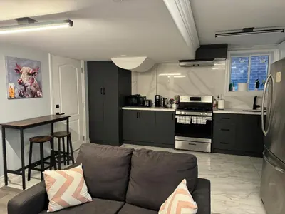 a living room with a couch and a kitchen at Oshawa Connect - Prime Location, Modern Space in Oshawa