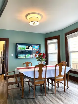 a dining room with a table with chairs and a tv at Cozy Suite-Walk to the Falls in Niagara Falls