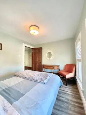 a bedroom with a bed and a red chair at Cozy Suite-Walk to the Falls in Niagara Falls