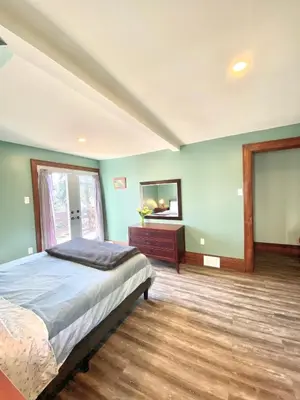 a bedroom with a bed and a dresser and a mirror at Cozy Suite-Walk to the Falls in Niagara Falls