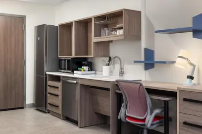 a kitchen with a desk with a chair and a refrigerator at Home2 Suites By Hilton Vaughan Toronto On in Vaughan