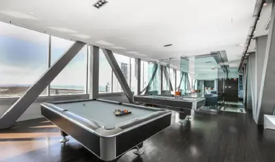 a pool table in a room with windows at Two Storey Penthouse with 2 Parkings and Lake & City Views in Toronto