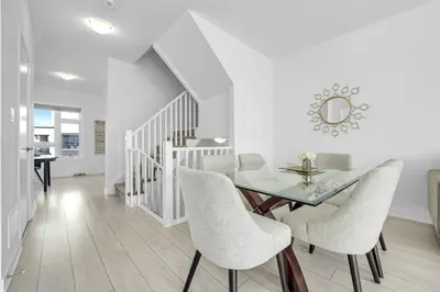 a dining room with a glass table and chairs at Stylish 4-Bed Home with Backyard in Prime Location in Burlington
