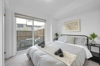 a bedroom with a bed with two towels on it at Stylish 4-Bed Home with Backyard in Prime Location in Burlington
