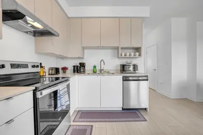 a kitchen with white cabinets and stainless steel appliances at Stylish 4-Bed Home with Backyard in Prime Location in Burlington
