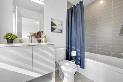 a bathroom with a toilet and a sink and a bath tub at Stylish 4-Bed Home with Backyard in Prime Location in Burlington
