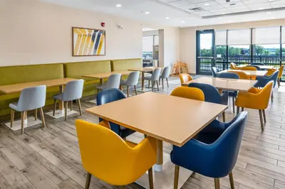 a dining room with tables and chairs at Comfort Inn & Suites in Bradford