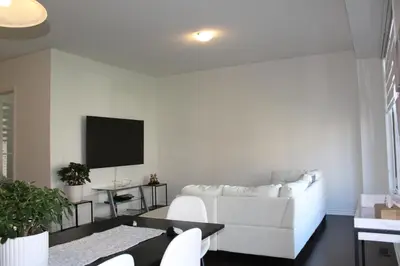 a living room with a white couch and a tv at West Oak, Detached New Modern House In South Barrie - Built H plus ME Technology in Barrie