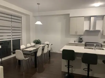 a kitchen with a table and chairs in a kitchen at West Oak, Detached New Modern House In South Barrie - Built H plus ME Technology in Barrie