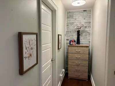 a hallway with a white door and a dresser at Chapman in Toronto