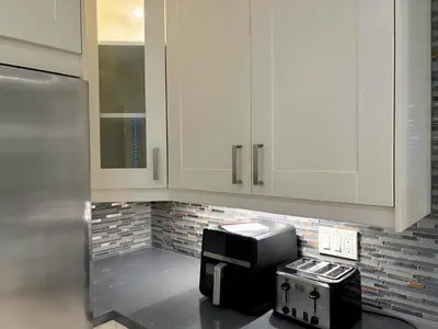 a kitchen with white cabinets and a microwave at Chapman in Toronto