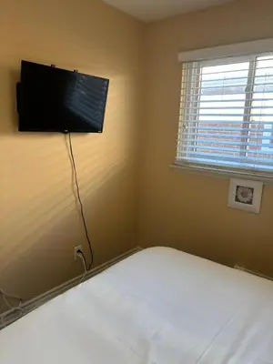 a bedroom with a bed with a flat screen tv on the wall at Chapman in Toronto