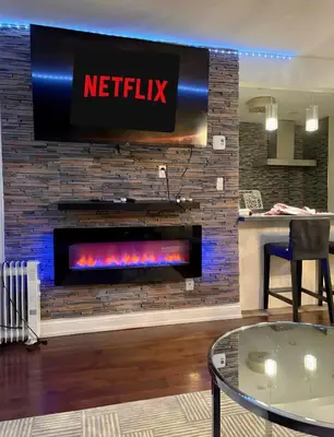 a fireplace with a netflix sign on a brick wall at Chapman in Toronto