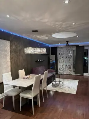 a dining room with a table and white chairs at Chapman in Toronto