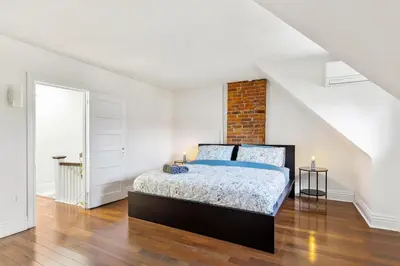 a bedroom with a bed and a brick wall at Stylish & Spacious 3BR in Downtown Toronto in Toronto