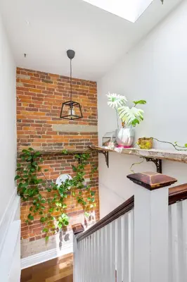 a brick wall in a room with plants at Stylish & Spacious 3BR in Downtown Toronto in Toronto