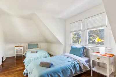 a bedroom with two beds and two windows at Stylish & Spacious 3BR in Downtown Toronto in Toronto