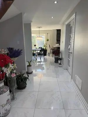 a living room with a large tile floor with potted plants at Private Single Bedroom in City Centre Q66 in Mississauga