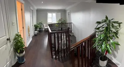 a hallway with potted plants and a wooden staircase at Bright Private Single Bedroom Q33 in Mississauga
