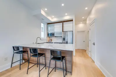 a kitchen with a large island with four bar stools at Toronto Midtown Home Suites in Toronto