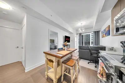 a kitchen with a wooden table in a room at Modern Condo with Balcony, Gym and Free Parking in Toronto