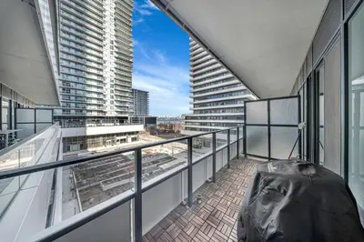 a balcony with a view of a large building at Modern Condo with Balcony, Gym and Free Parking in Toronto