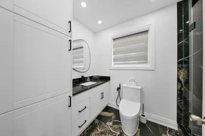 a bathroom with a toilet and a sink at Hidden 3BR Gem with Workspace, Fast wifi and Parking in Toronto