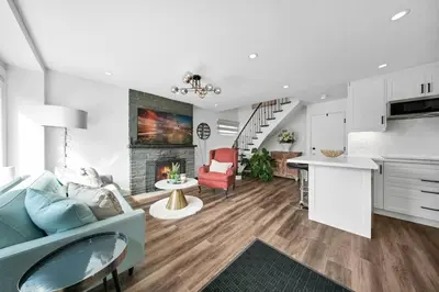 a kitchen and living room with a couch and a fireplace at Hidden 3BR Gem with Workspace, Fast wifi and Parking in Toronto