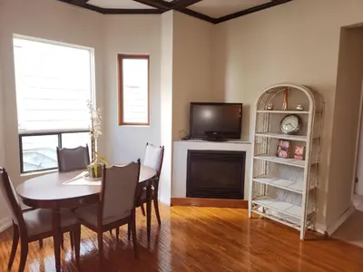 a dining room with a table and a tv at Cozy 2-Bedroom Downtown Apartment in London