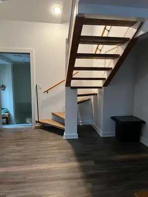an empty room with a staircase in a house at Cozy 2-Bedroom Downtown Apartment in London