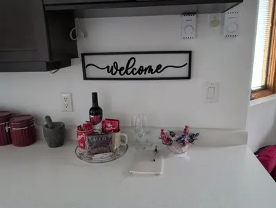 a kitchen counter with a welcome sign on the wall at Cozy 2-Bedroom Downtown Apartment in London