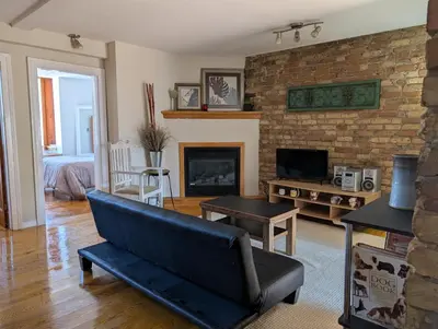 a living room with a couch and a fireplace at Cozy 2-Bedroom Downtown Apartment in London