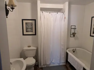 a bathroom with a toilet and a tub and a sink at Cozy 2-Bedroom Downtown Apartment in London