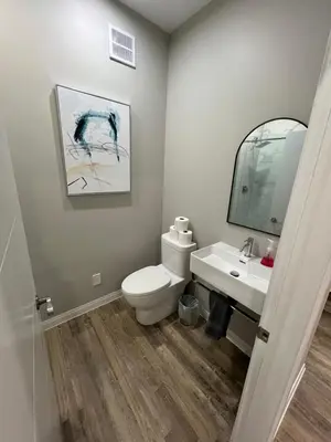 a bathroom with a toilet and a sink and a mirror at ENTIRE BACHELOR UNIT EN-SUITE ACROSS FROM GOOGLE - br2 in Kitchener