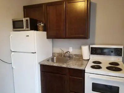 a kitchen with a white refrigerator and a sink at The Rosehall PEC Waterfront Stay in Wellington