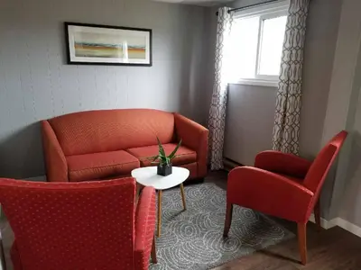 a living room with a couch and two chairs and a table at The Rosehall PEC Waterfront Stay in Wellington
