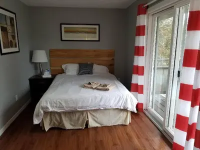 a bedroom with a bed with two slippers on it at The Rosehall PEC Waterfront Stay in Wellington