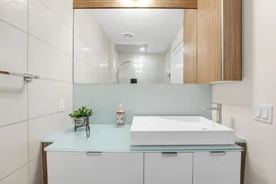 a bathroom with a white sink and a mirror at Boho 2bdrm Sleeps 6 near Rogers MTCC Union CN tower in Toronto