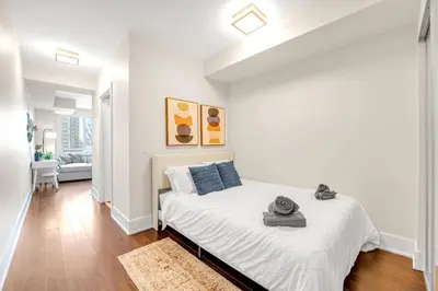 a white bedroom with a bed in a room at Boho 2bdrm Sleeps 6 near Rogers MTCC Union CN tower in Toronto