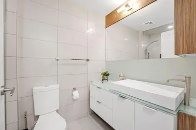 a white bathroom with a toilet and a sink at Boho 2bdrm Sleeps 6 near Rogers MTCC Union CN tower in Toronto